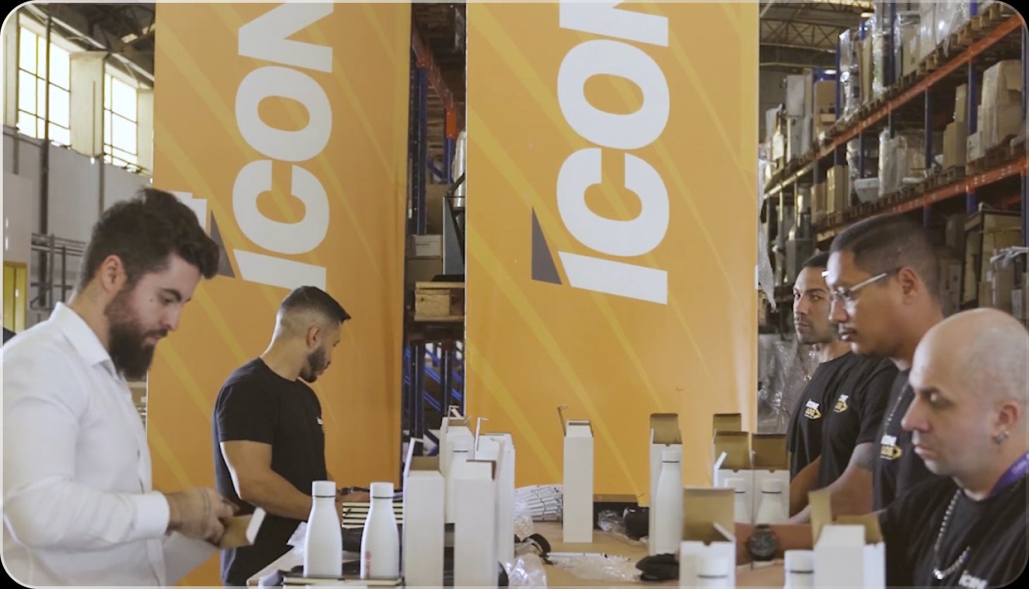 Equipe conferindo materiais em frente a banners Ícone Log